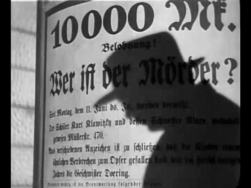 Hans Beckert's profile in shadow falls upon the sign offering a reward for the killer of children.
